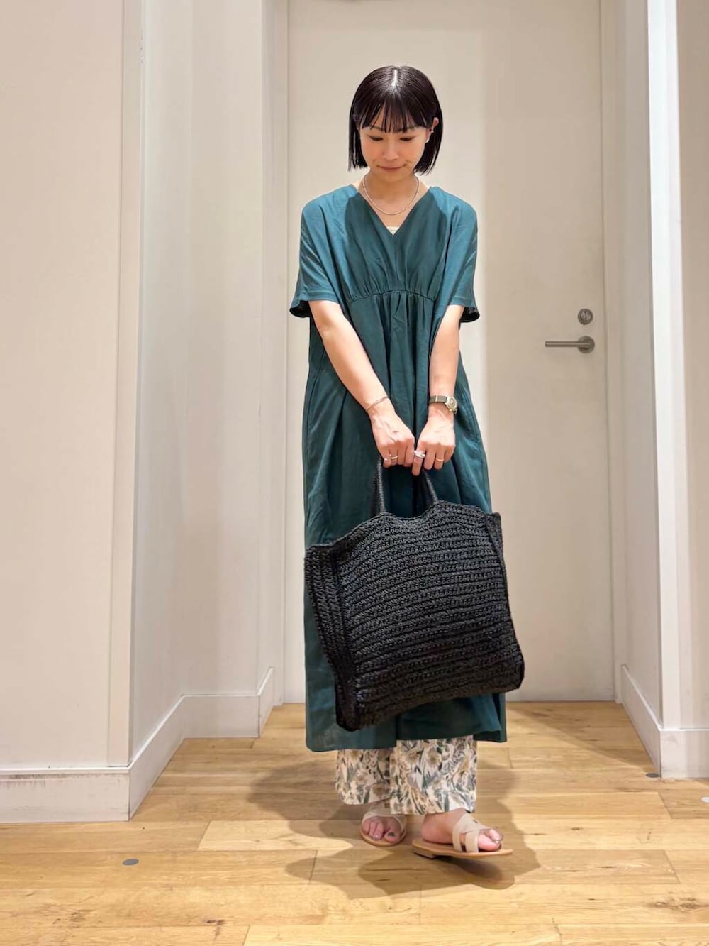 ブラック系のトートバッグ、ホワイト系のサンダル、ベージュ系のその他パンツを着用したレディースの夏コーディネートの3枚目の写真