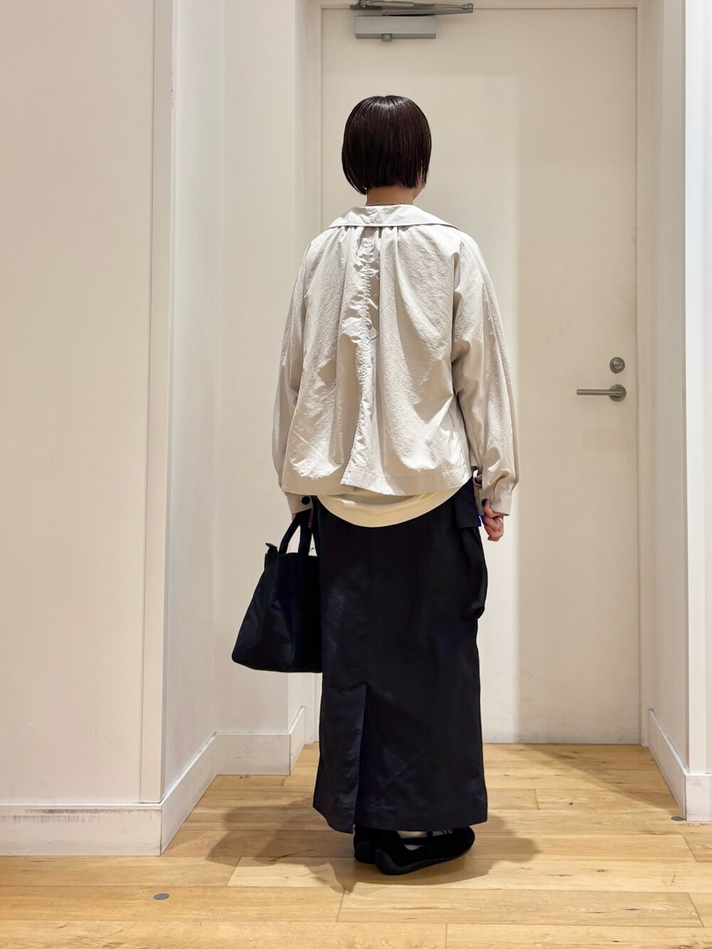 ホワイト系のTシャツ/カットソー、ベージュ系のテーラードジャケット、ブラック系のスカートを着用したレディースの春コーディネートの5枚目の写真