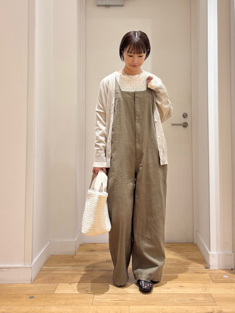 ホワイト系のTシャツ/カットソー、ベージュ系のカーディガン/ボレロ、グリーン系のサロペット/オーバーオールを着用したレディースの春コーディネートの4枚目の写真