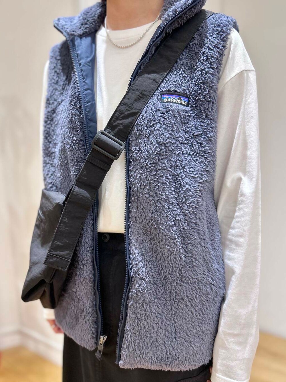 ブラック系のショルダーバッグ、ブラック系のスカート、ホワイト系のTシャツ/カットソーを着用したレディースの秋コーディネートの6枚目の写真