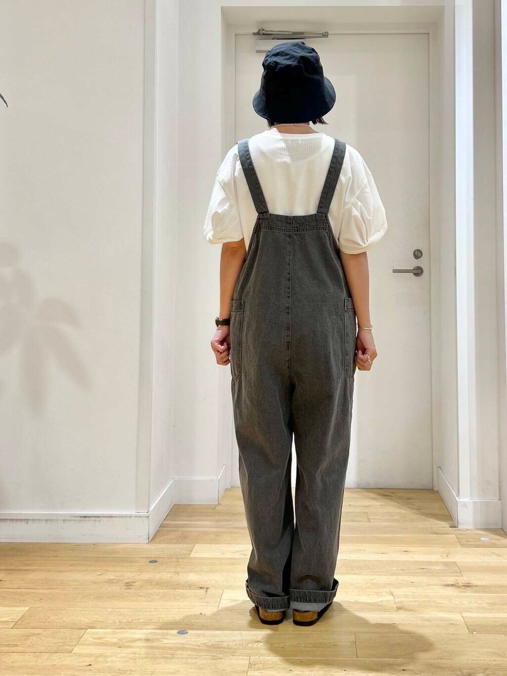 ブラック系のサンダル、グレー系のサロペット/オーバーオール、ホワイト系のTシャツ/カットソーを着用したレディースの夏コーディネートの5枚目の写真