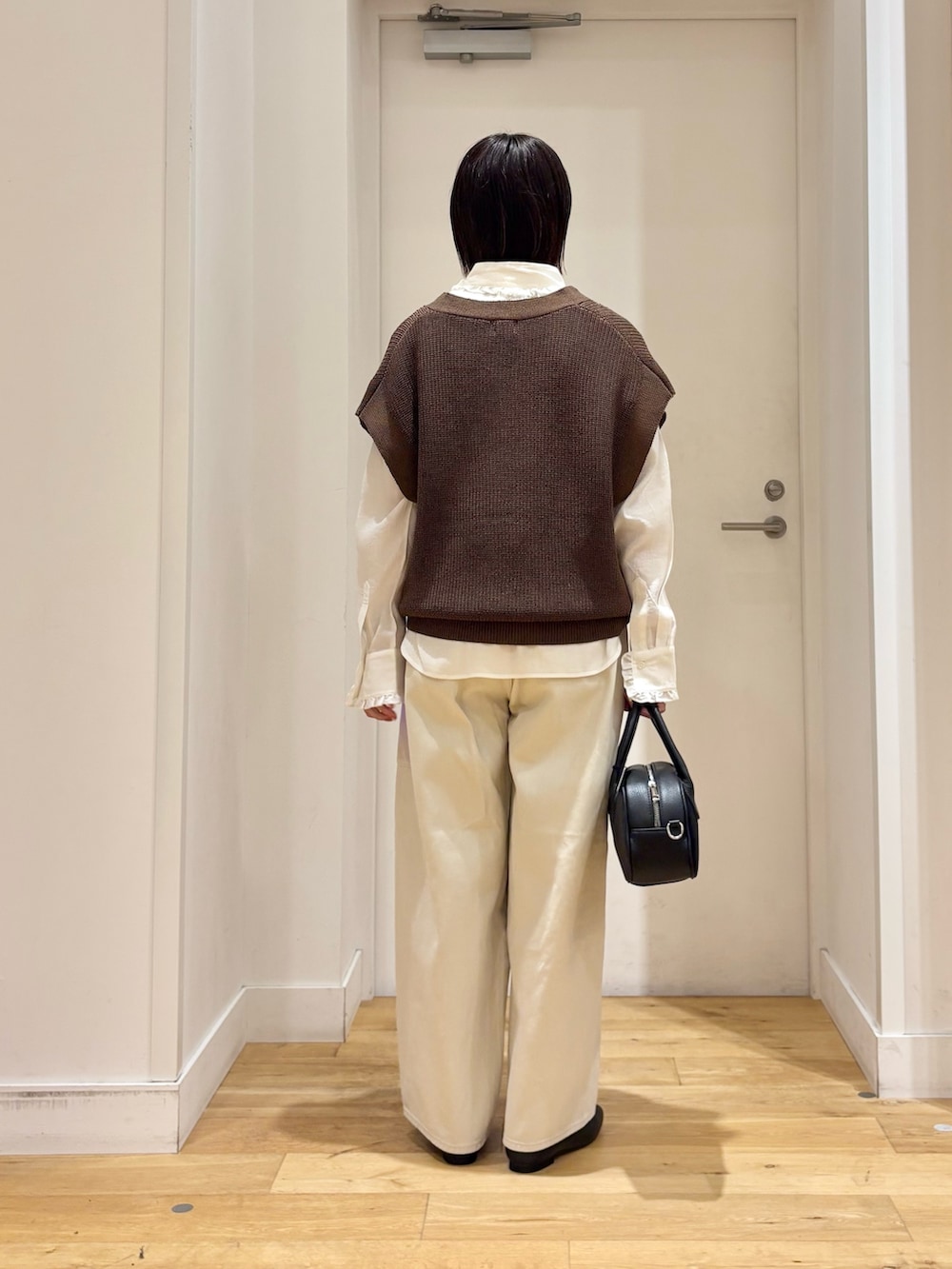 ブラウン系のベスト、ホワイト系のその他パンツ、ホワイト系のシャツ/ブラウスを着用したレディースの秋コーディネートの4枚目の写真
