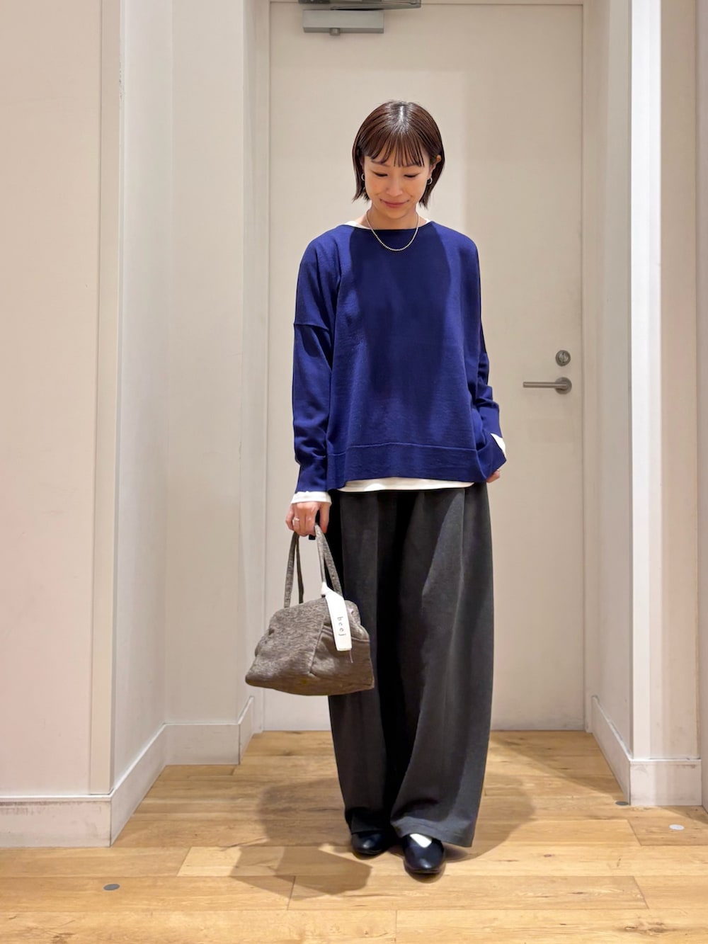ブルー系のニット/セーター、グレー系のその他パンツ、ブラック系のパンプスを着用したレディースの秋コーディネートの2枚目の写真