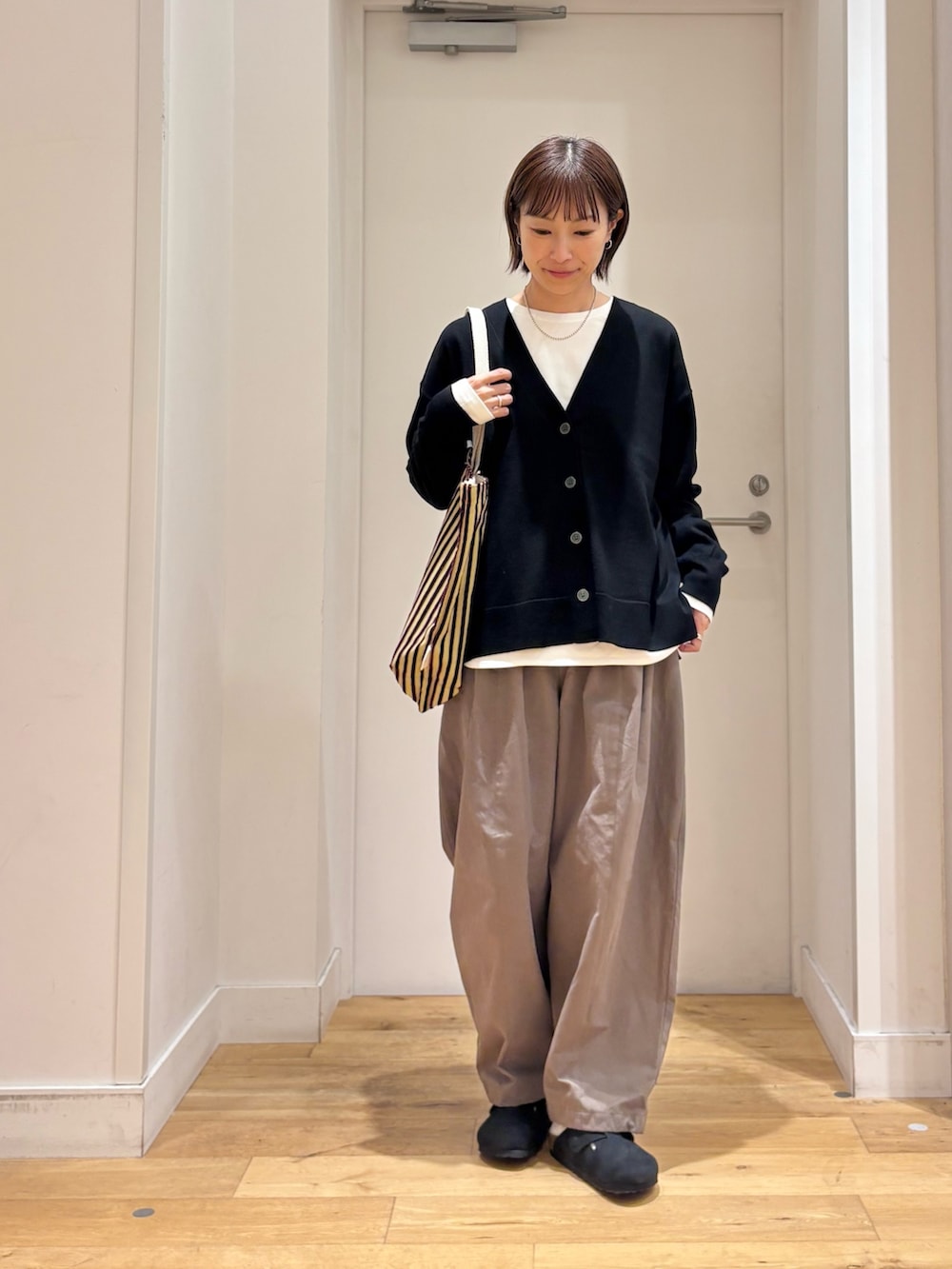 ブラック系のカーディガン/ボレロ、ホワイト系のTシャツ/カットソー、ブラック系のその他シューズを着用したレディースの秋コーディネートの4枚目の写真