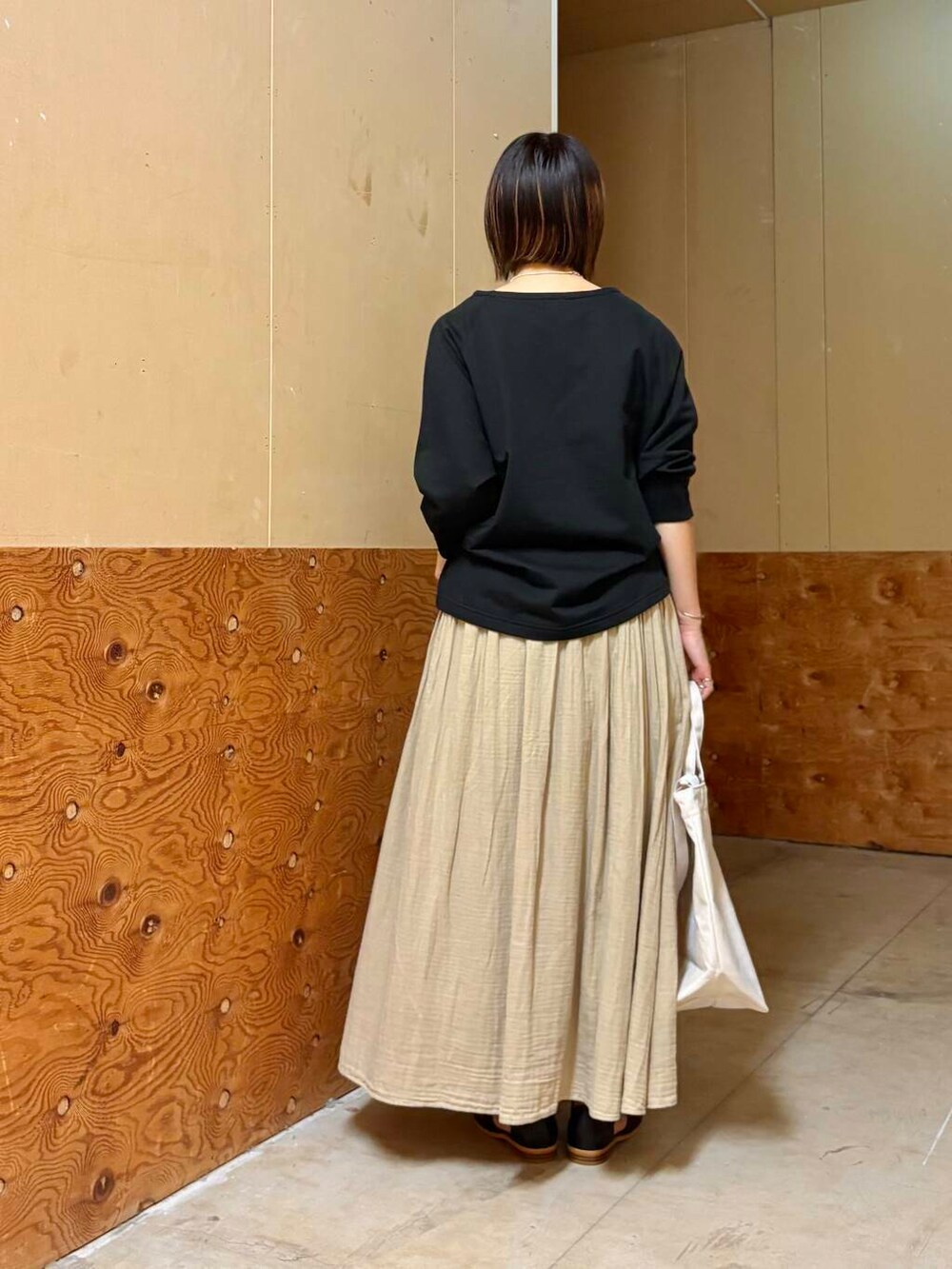 ブラック系のサンダル、ベージュ系のスカート、ブラック系のTシャツ/カットソーを着用したレディースの春コーディネートの5枚目の写真