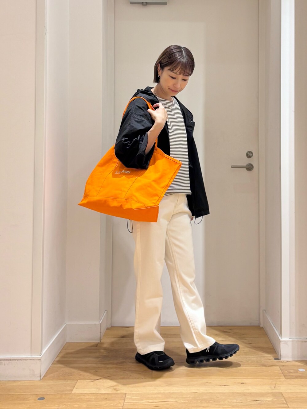 ホワイト系のTシャツ/カットソー、ブラック系のナイロンジャケット、ベージュ系のその他パンツを着用したレディースの夏コーディネートの5枚目の写真