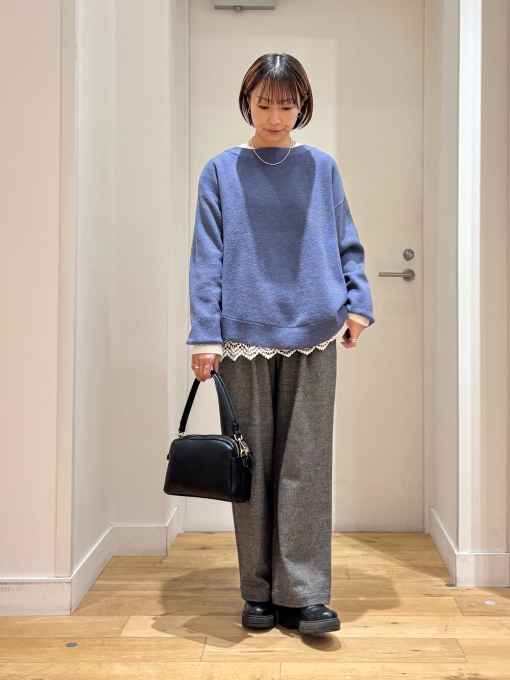 ブルー系のニット/セーター、グレー系のその他パンツ、ホワイト系のTシャツ/カットソーを着用したレディースの冬コーディネートの5枚目の写真