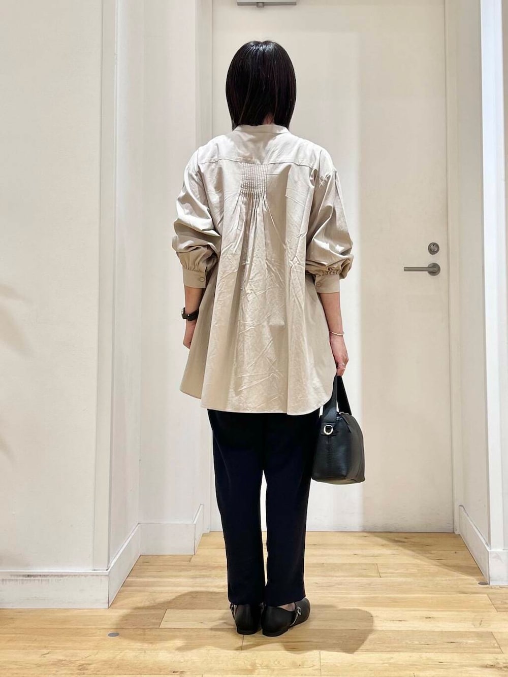 ベージュ系のシャツ/ブラウス、ブルー系のその他パンツ、ブラック系のパンプスを着用したレディースの冬コーディネートの6枚目の写真