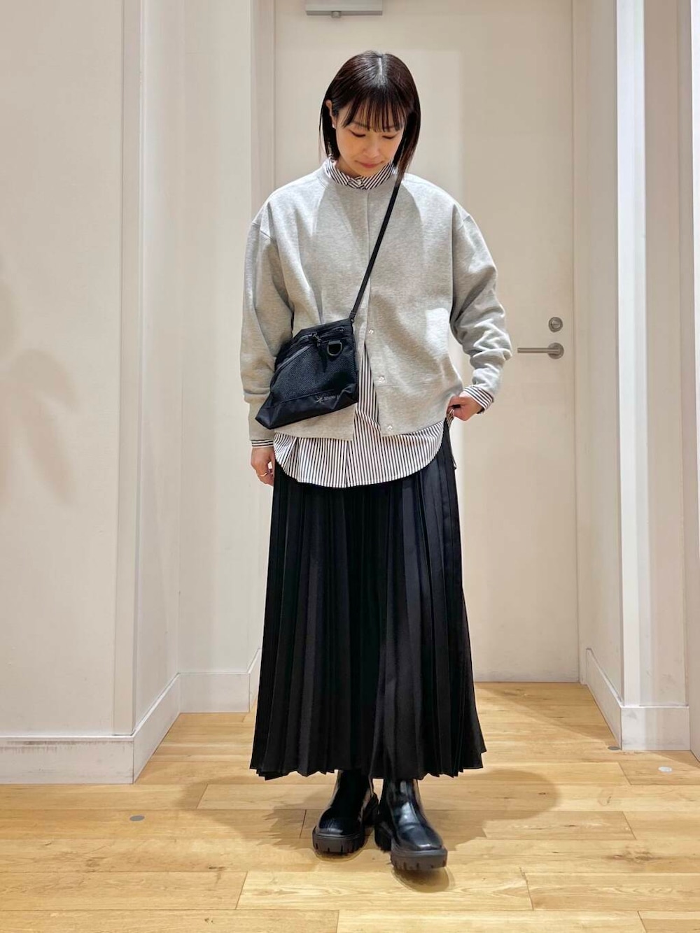 ブルー系のシャツ/ブラウス、ブラック系のブーツ、ブラック系のショルダーバッグを着用したレディースの冬コーディネートの3枚目の写真