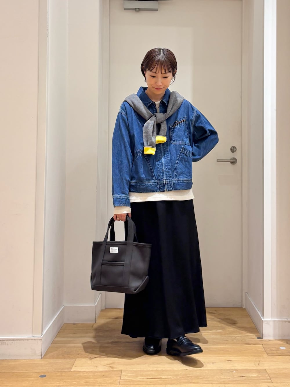 グレー系のカーディガン/ボレロ、ブルー系のデニムジャケット、ブラック系のローファーを着用したレディースの秋コーディネートの3枚目の写真