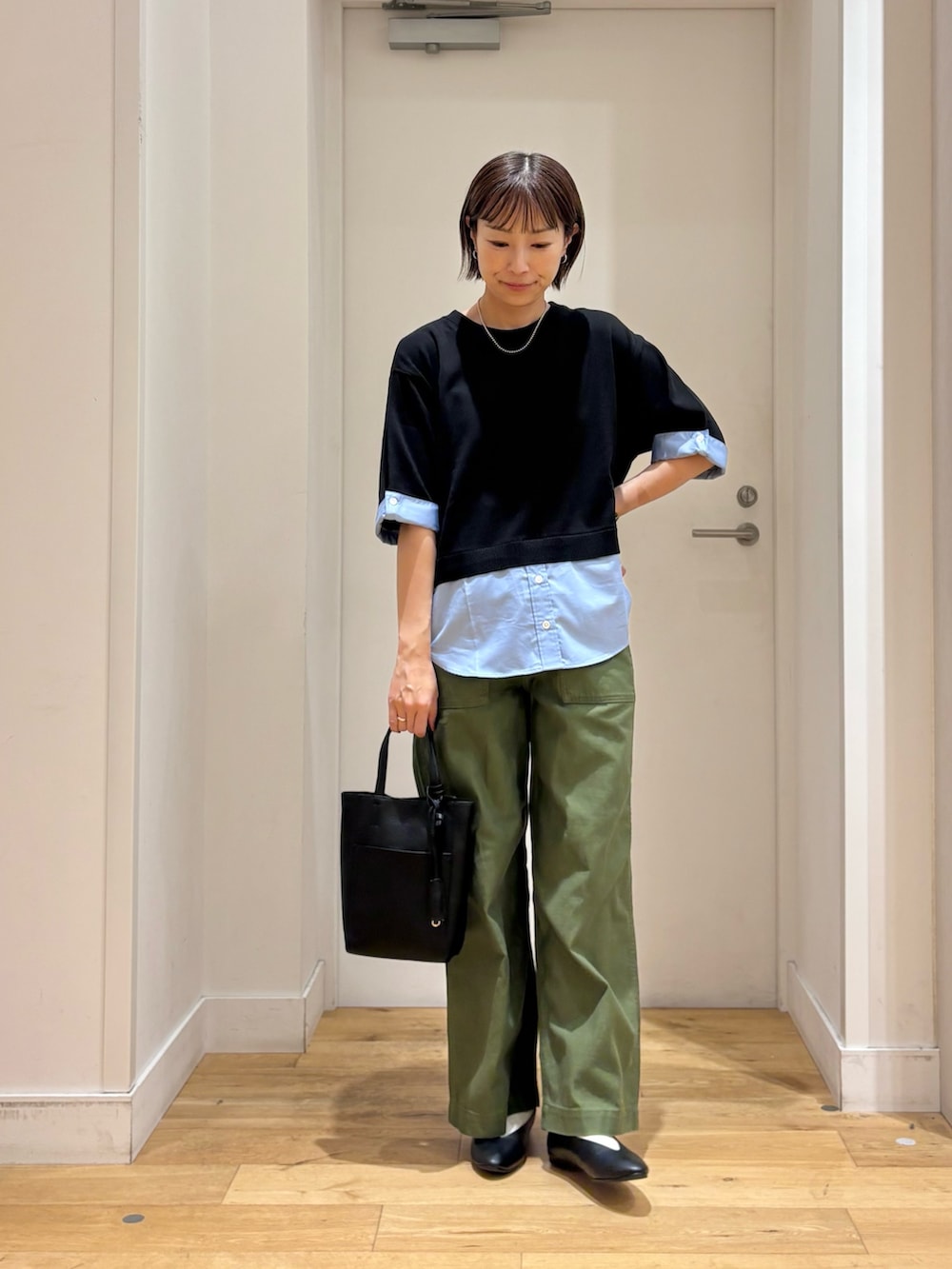 グリーン系のその他パンツ、ブラック系のニット/セーター、ブラック系のトートバッグを着用したレディースの秋コーディネートの2枚目の写真