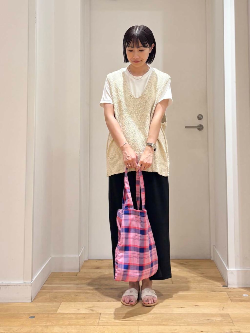 ホワイト系のサンダル、ホワイト系のTシャツ/カットソー、ブラック系のスカートを着用したレディースの夏コーディネートの4枚目の写真