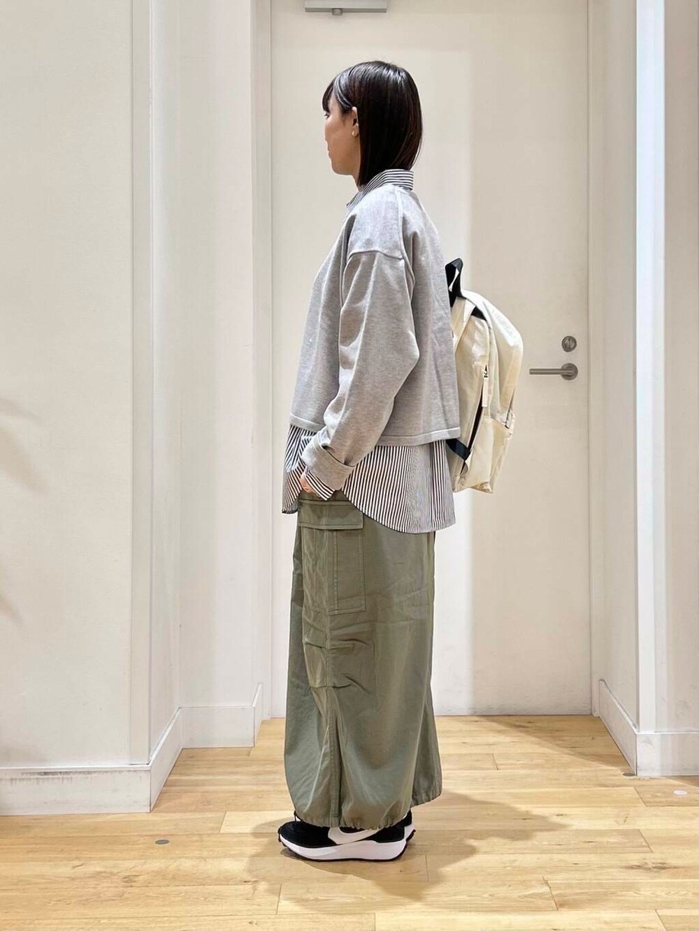 ブルー系のシャツ/ブラウス、グリーン系のスカート、ホワイト系のバックパック/リュックを着用したレディースの冬コーディネートの4枚目の写真