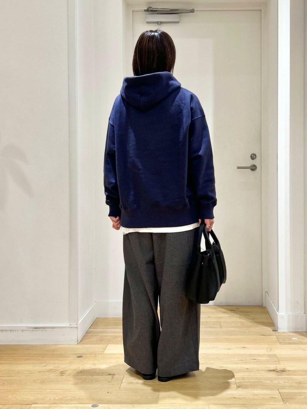 ブラック系のトートバッグ、ブラック系のバレエシューズ、ブルー系のパーカーを着用したレディースの秋コーディネートの5枚目の写真