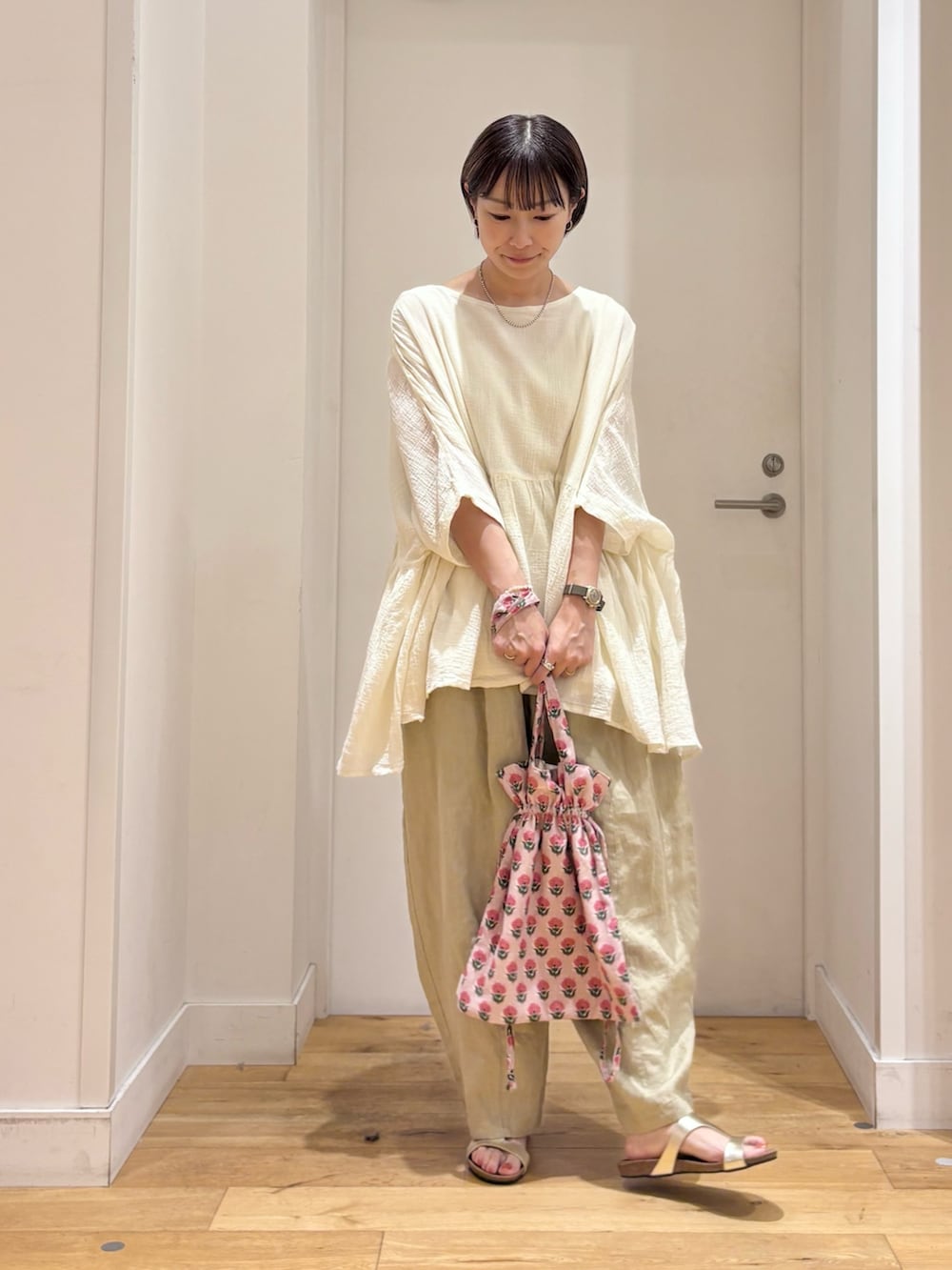 ホワイト系のシャツ/ブラウス、ベージュ系のその他パンツ、ゴールド系のサンダルを着用したレディースの夏コーディネートの3枚目の写真