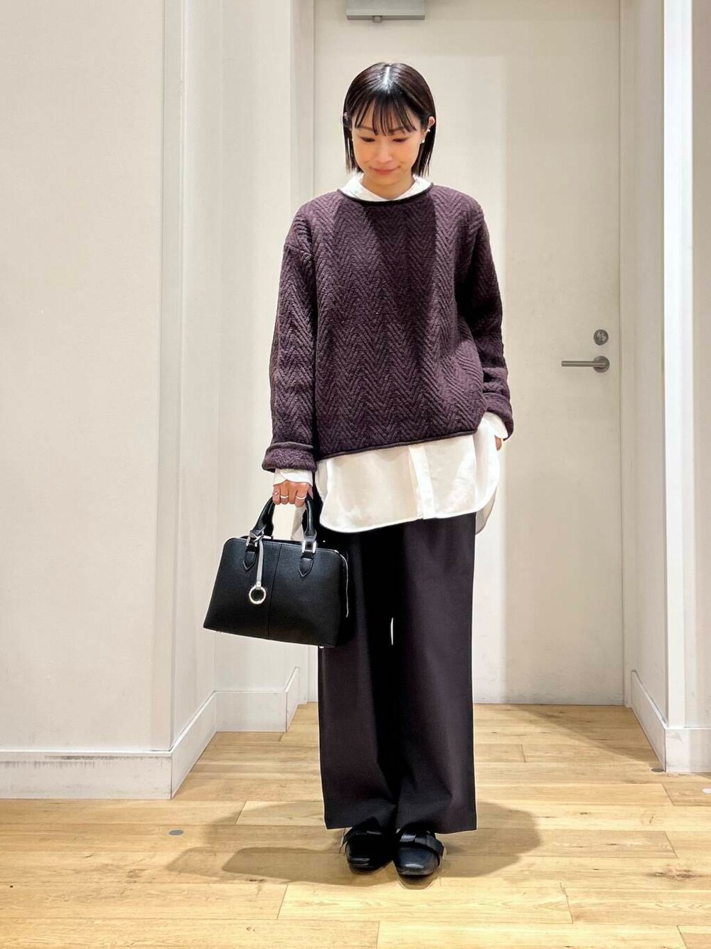 ブラック系のドレスシューズ、ホワイト系のシャツ/ブラウス、ブラック系のハンドバッグを着用したレディースの冬コーディネートの3枚目の写真