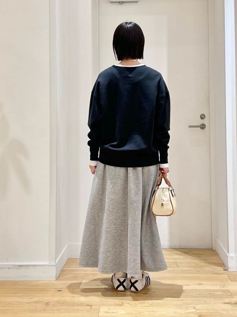 ホワイト系のTシャツ/カットソー、グレー系のスカート、ホワイト系のスニーカーを着用したレディースの冬コーディネートの5枚目の写真