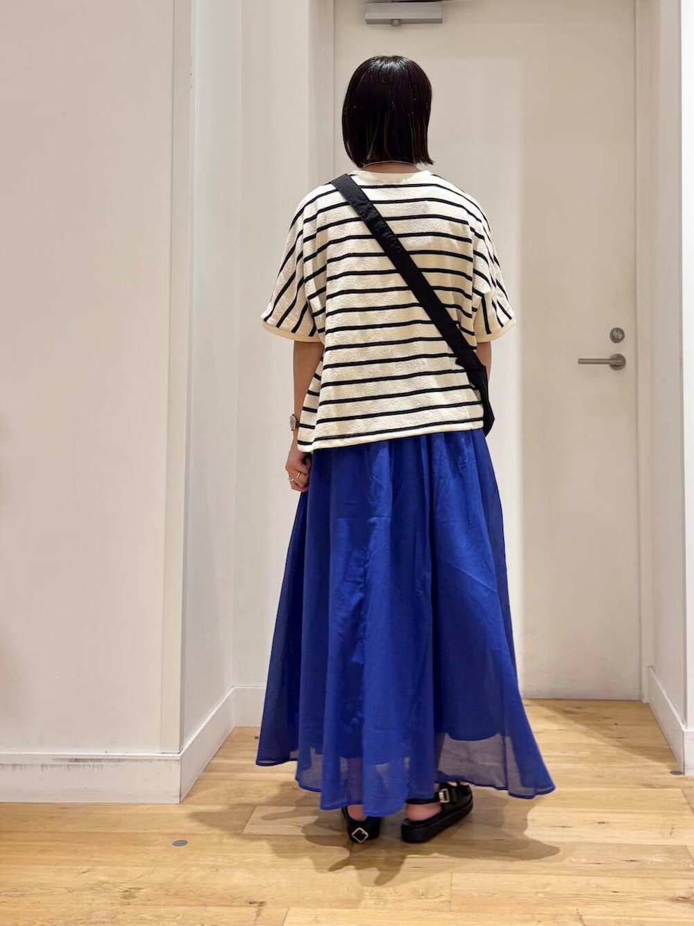 ブルー系のスカート、ブラック系のサンダル、ブラック系のショルダーバッグを着用したレディースの夏コーディネートの5枚目の写真