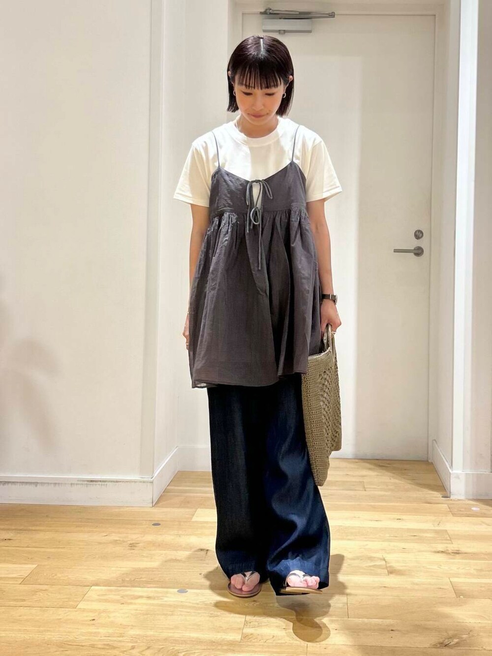 ブルー系のデニムパンツ、ホワイト系のTシャツ/カットソー、シルバー系のサンダルを着用したレディースの夏コーディネートの3枚目の写真