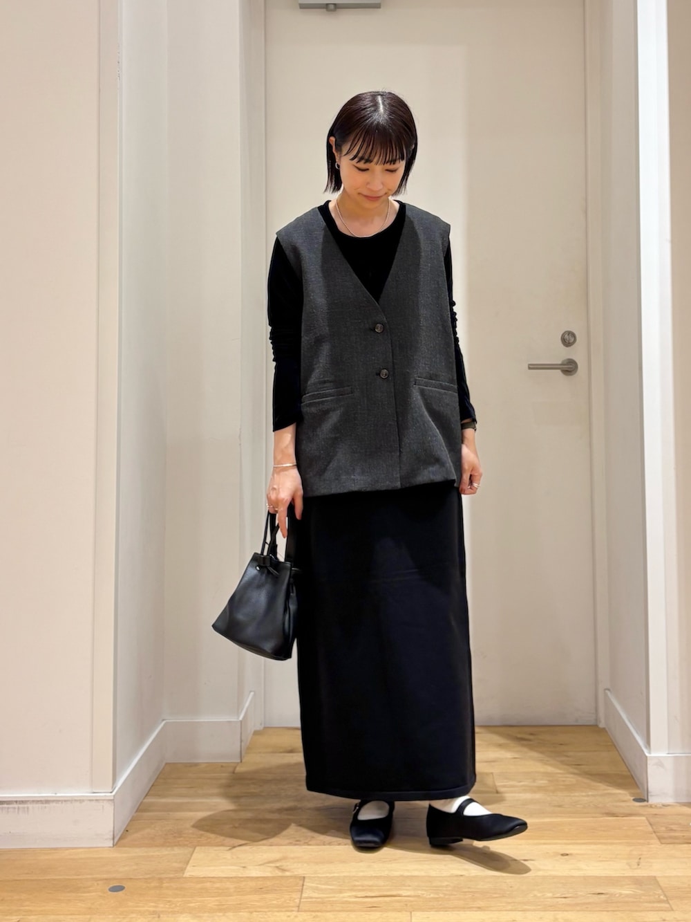 ブラック系のショルダーバッグ、ブラック系のTシャツ/カットソー、ブラック系のその他アウターを着用したレディースの秋コーディネートの5枚目の写真