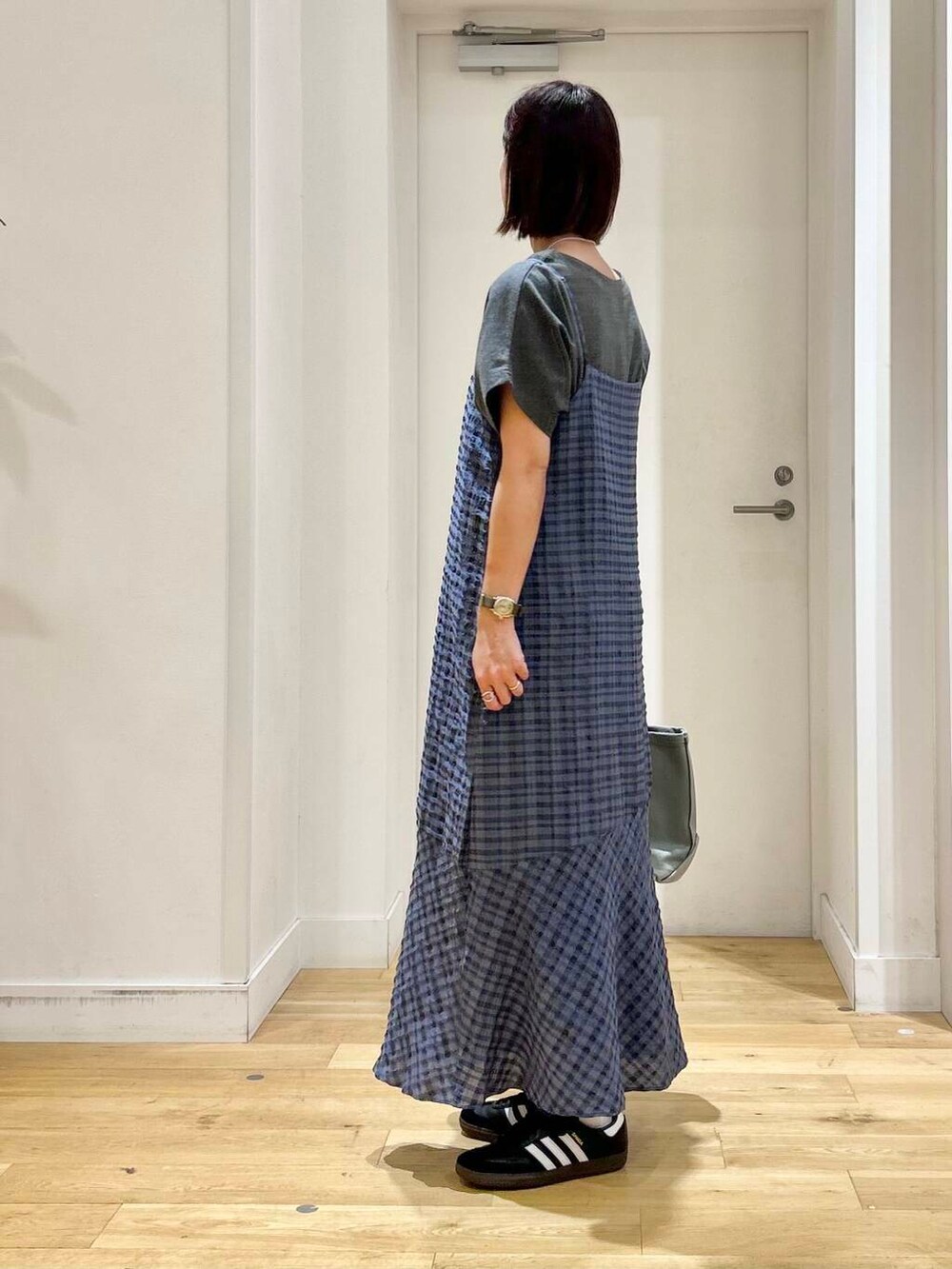 グレー系のTシャツ/カットソー、ブルー系のワンピース、ブラック系のスニーカーを着用したレディースの夏コーディネートの4枚目の写真