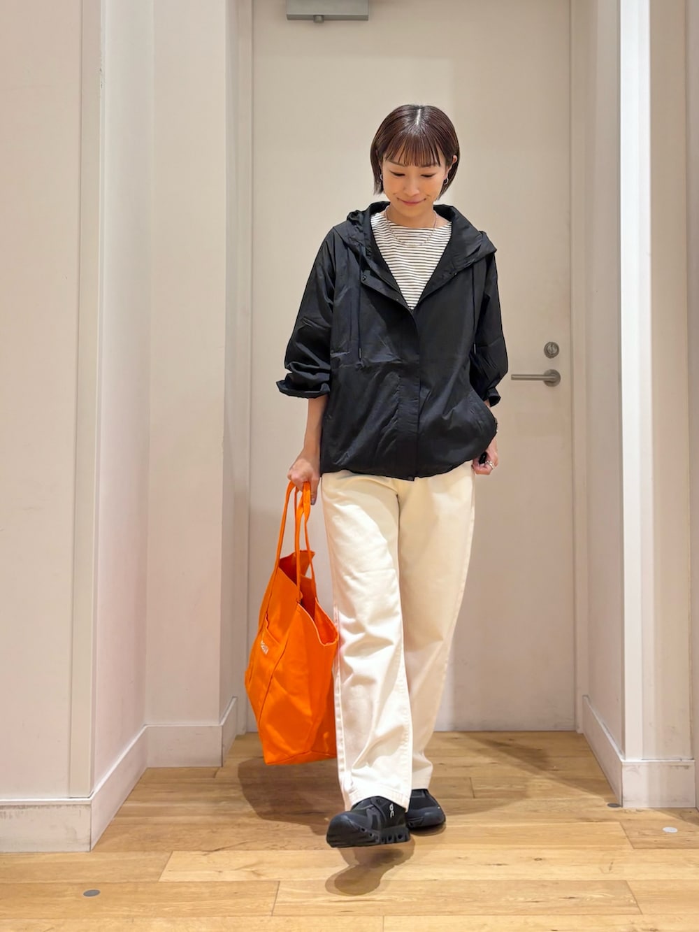 ホワイト系のTシャツ/カットソー、ブラック系のナイロンジャケット、ベージュ系のその他パンツを着用したレディースの夏コーディネートの4枚目の写真