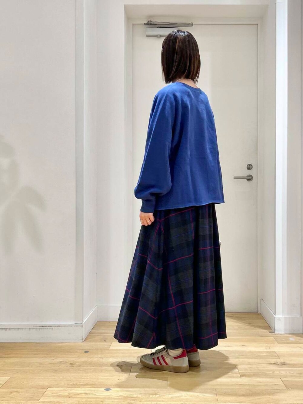 ブルー系のTシャツ/カットソー、ベージュ系のトートバッグ、ホワイト系のスニーカーを着用したレディースの秋コーディネートの6枚目の写真