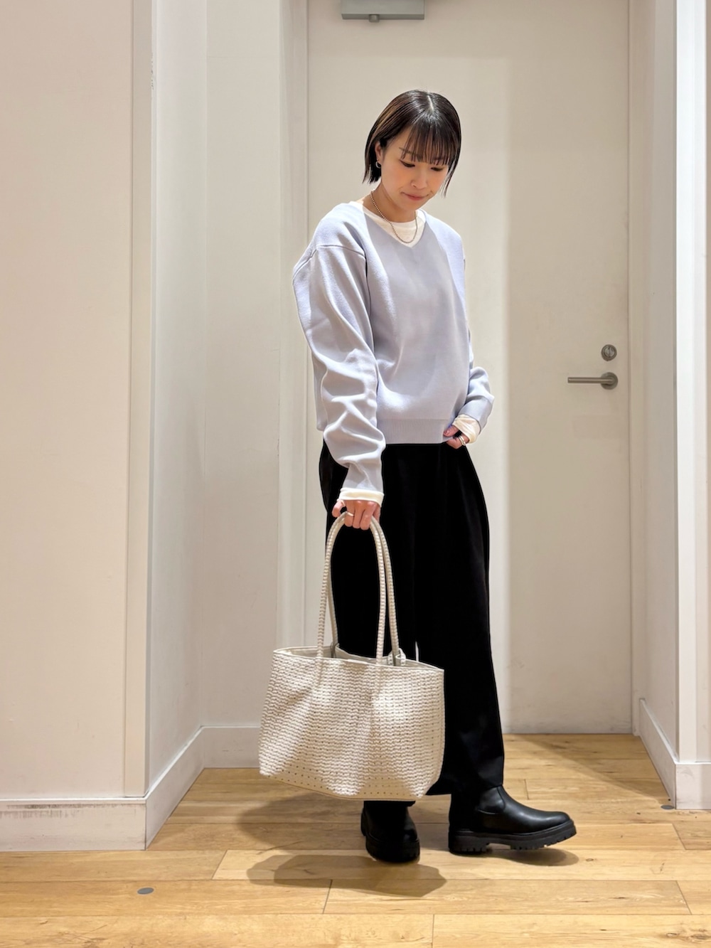 ブラック系のその他パンツ、ホワイト系のトートバッグ、ブラック系のブーツを着用したレディースの冬コーディネートの5枚目の写真