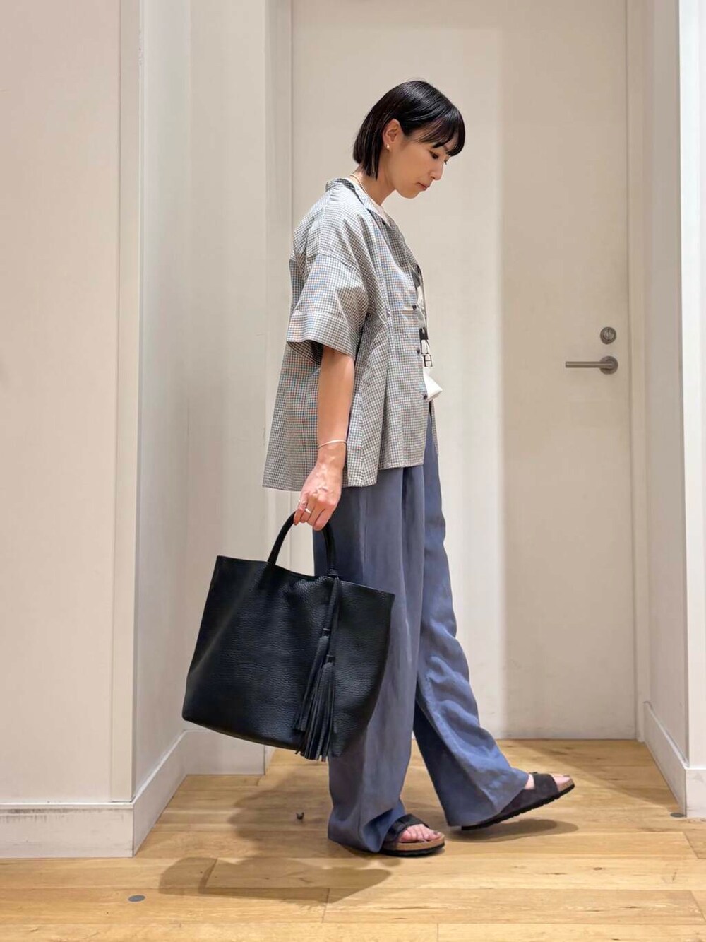 ブラック系のトートバッグ、グレー系のサンダル、ブルー系のその他パンツを着用したレディースの夏コーディネートの6枚目の写真