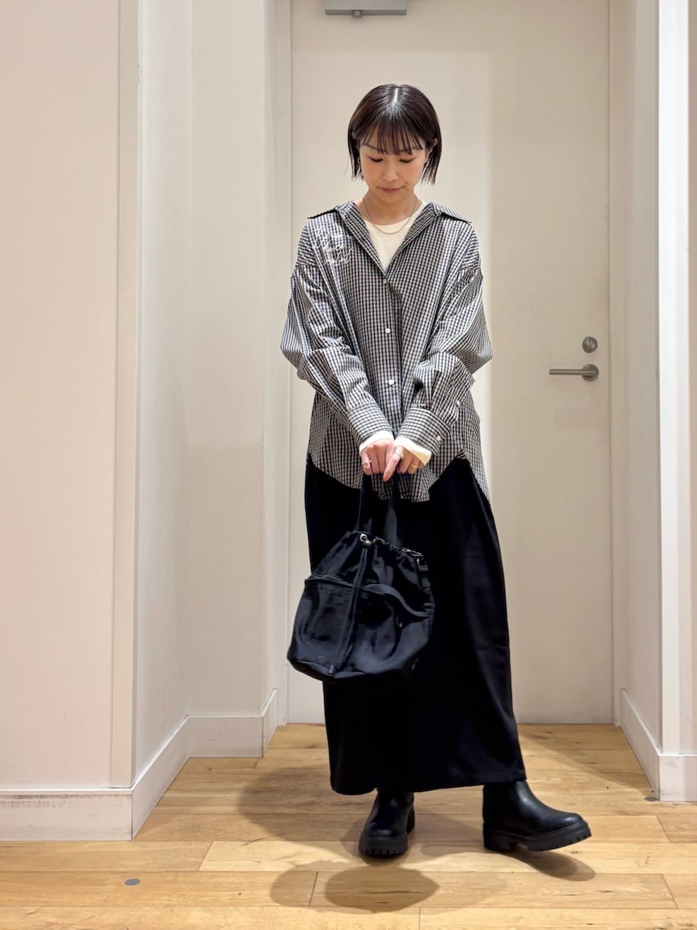 ブラック系のシャツ/ブラウス、ホワイト系のTシャツ/カットソー、ブラック系のショルダーバッグを着用したレディースの冬コーディネートの4枚目の写真