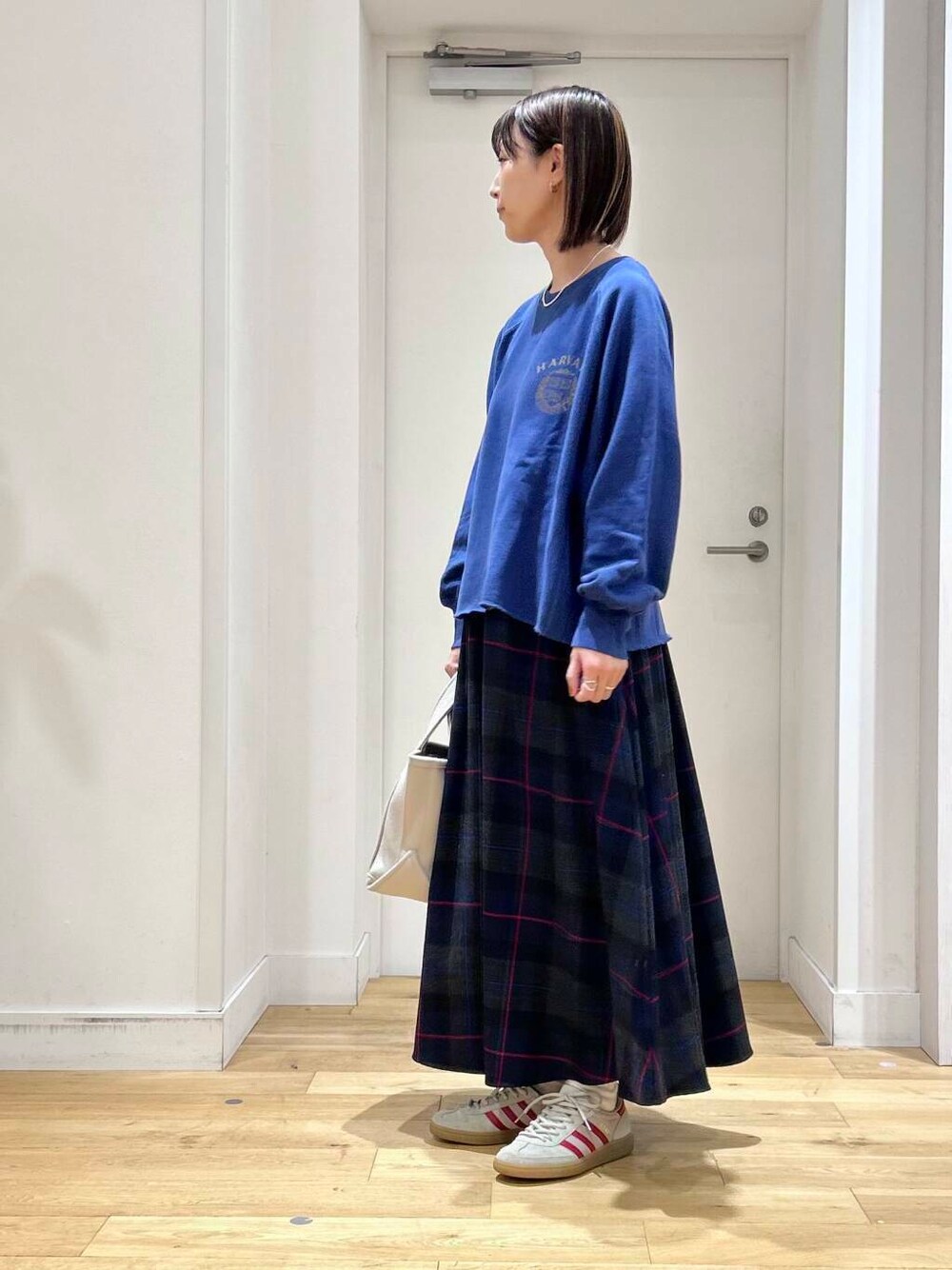 ブルー系のTシャツ/カットソー、ベージュ系のトートバッグ、ホワイト系のスニーカーを着用したレディースの秋コーディネートの4枚目の写真