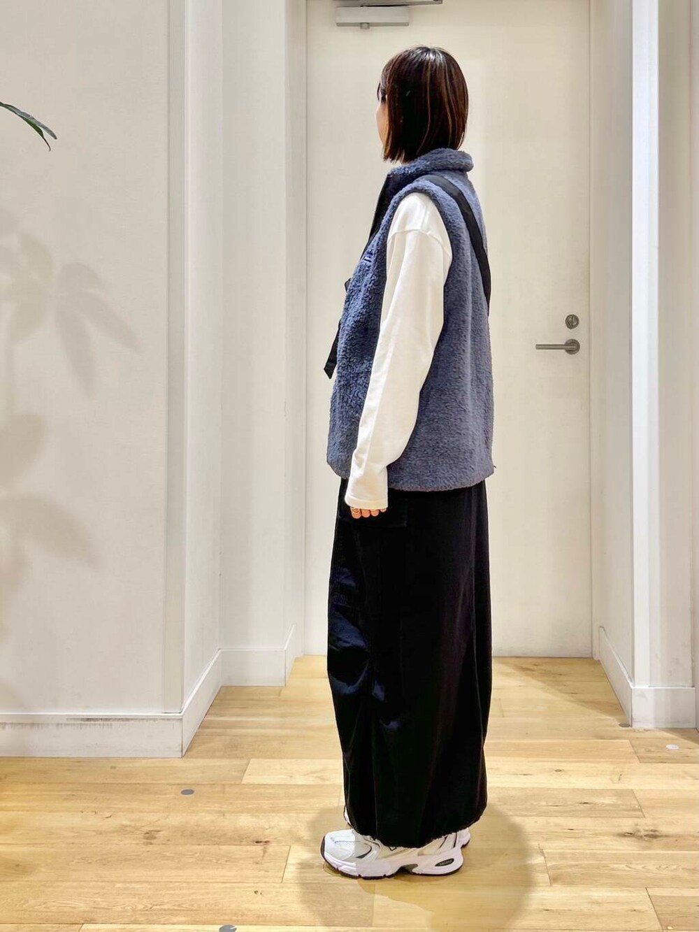ブラック系のショルダーバッグ、ブラック系のスカート、ホワイト系のTシャツ/カットソーを着用したレディースの秋コーディネートの4枚目の写真
