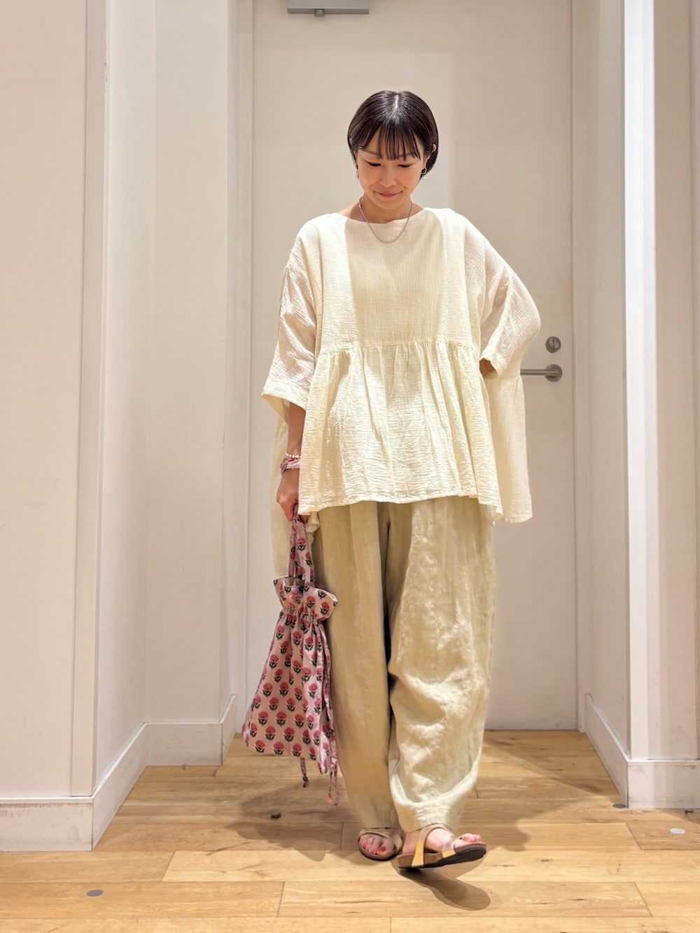 ホワイト系のシャツ/ブラウス、ベージュ系のその他パンツ、ゴールド系のサンダルを着用したレディースの夏コーディネートの4枚目の写真
