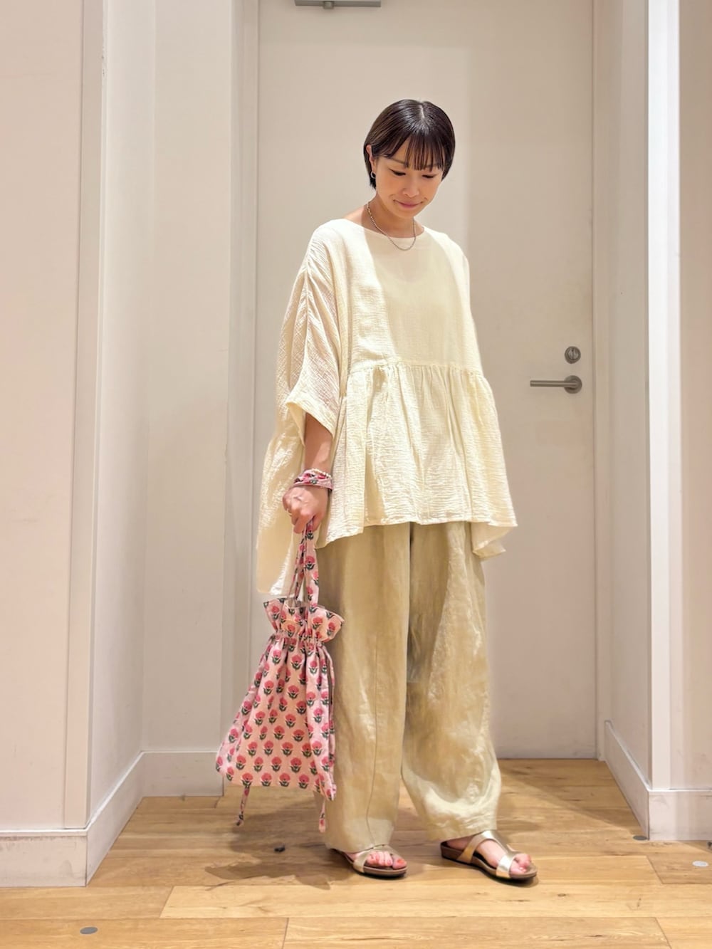 ホワイト系のシャツ/ブラウス、ベージュ系のその他パンツ、ゴールド系のサンダルを着用したレディースの夏コーディネートの5枚目の写真
