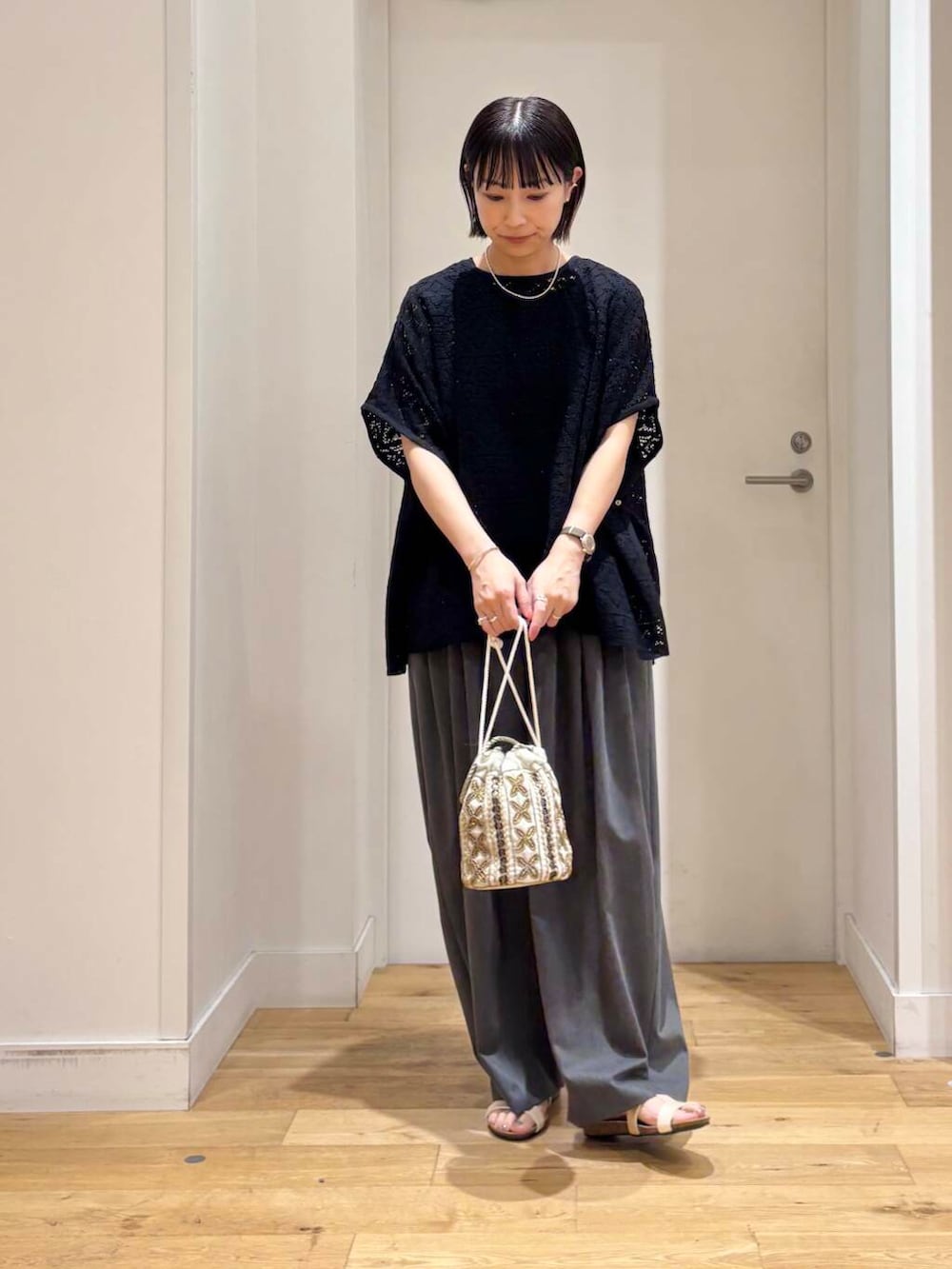 ホワイト系のショルダーバッグ、グレー系のその他パンツ、ホワイト系のサンダルを着用したレディースの夏コーディネートの2枚目の写真