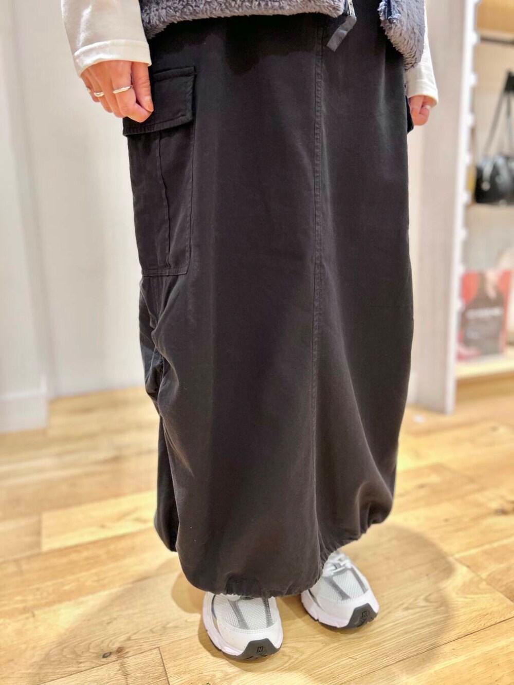 ブラック系のショルダーバッグ、ブラック系のスカート、ホワイト系のTシャツ/カットソーを着用したレディースの秋コーディネートの7枚目の写真