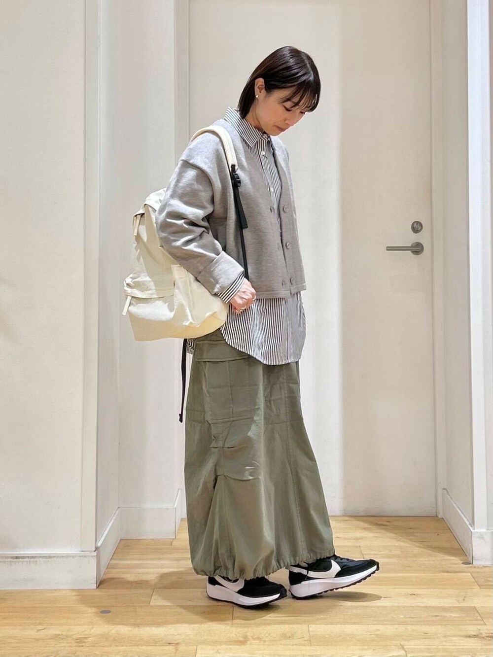 ブルー系のシャツ/ブラウス、グリーン系のスカート、ホワイト系のバックパック/リュックを着用したレディースの冬コーディネートの3枚目の写真