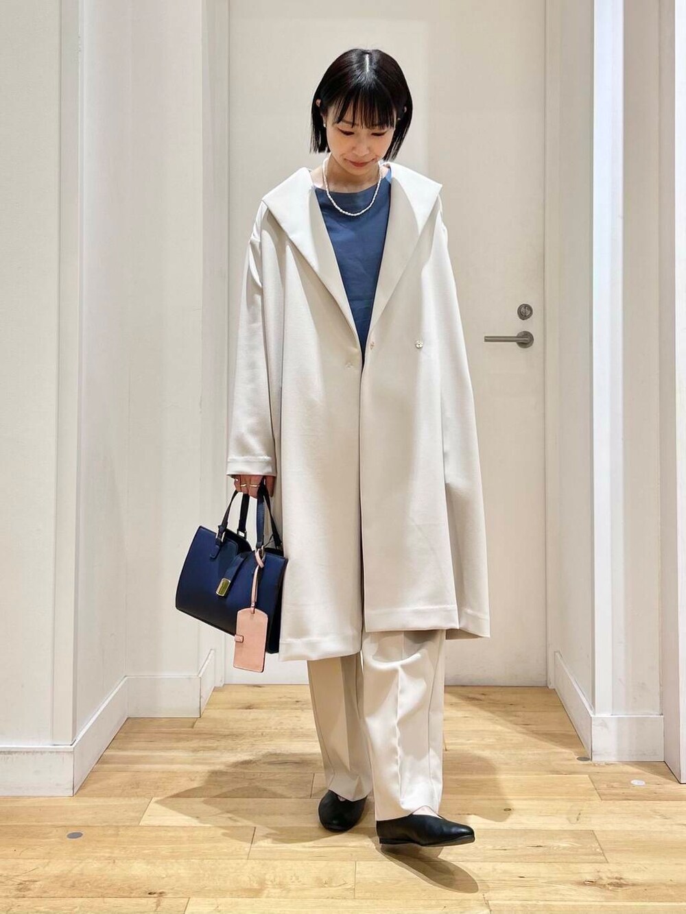 ブルー系のTシャツ/カットソー、ホワイト系のその他パンツ、ブラック系のパンプスを着用したレディースの冬コーディネートの4枚目の写真