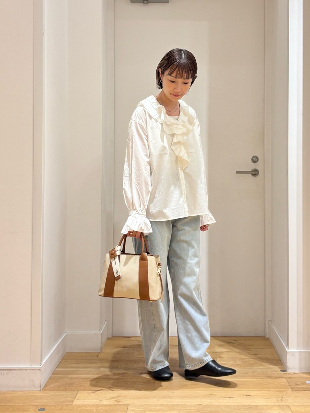 ホワイト系のシャツ/ブラウス、ブルー系のデニムパンツ、ブラック系のその他シューズを着用したレディースの秋コーディネートの4枚目の写真