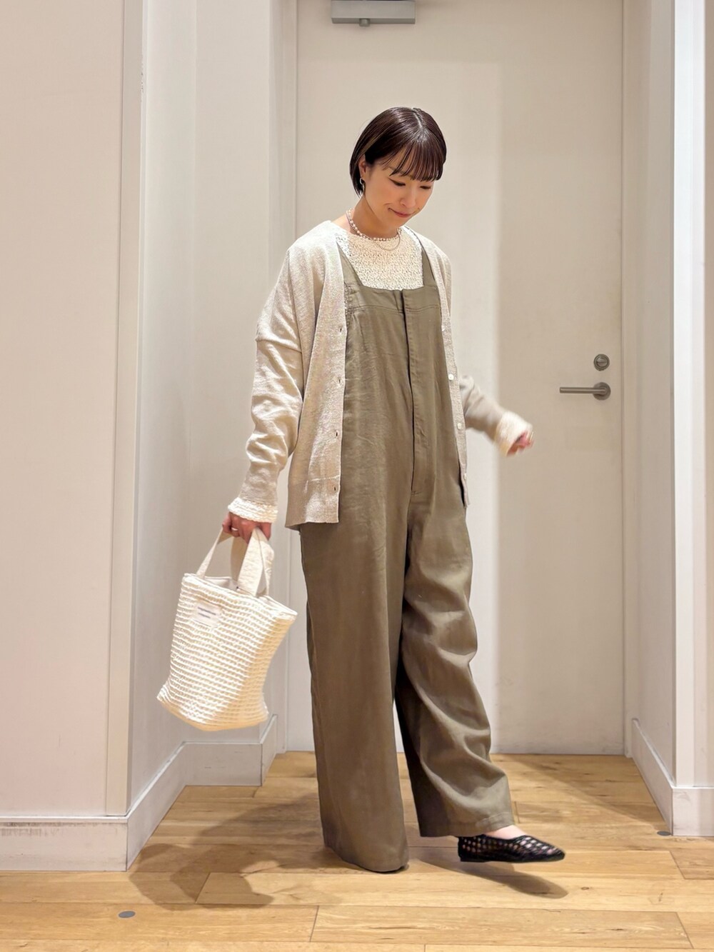 ホワイト系のTシャツ/カットソー、ベージュ系のカーディガン/ボレロ、グリーン系のサロペット/オーバーオールを着用したレディースの春コーディネートの5枚目の写真