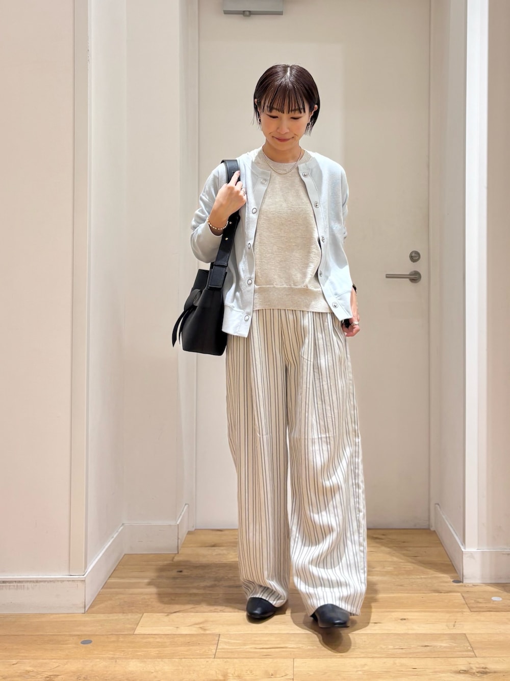 ブルー系のカーディガン/ボレロ、ベージュ系のTシャツ/カットソー、グレー系のその他パンツを着用したレディースの春コーディネートの2枚目の写真