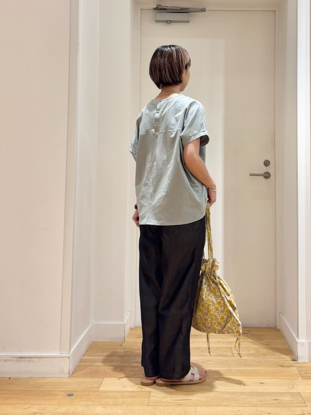 グリーン系のTシャツ/カットソー、ブラック系のデニムパンツ、イエロー系のトートバッグを着用したレディースの夏コーディネートの4枚目の写真