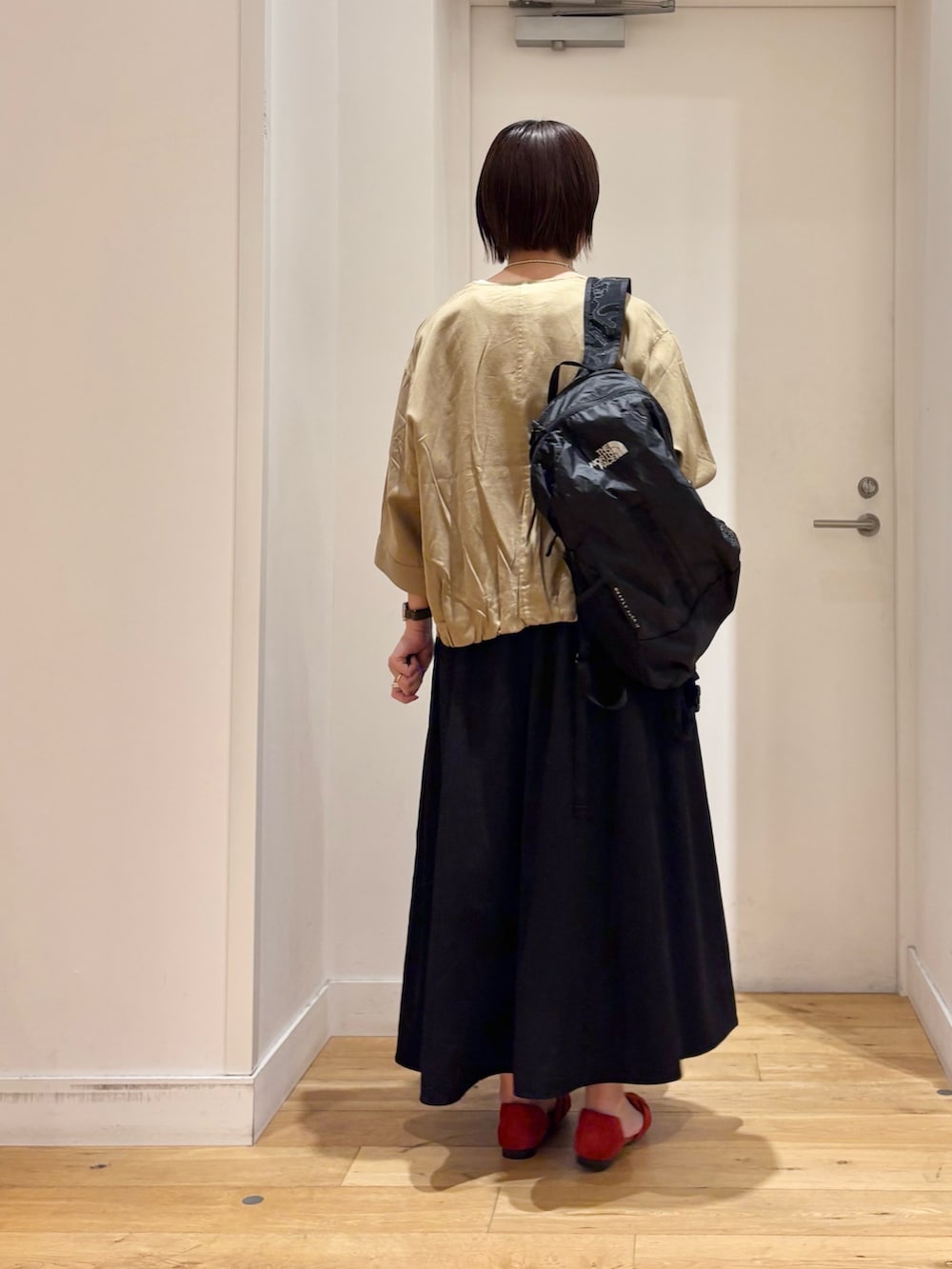 ベージュ系のシャツ/ブラウス、ブラック系のスカート、ホワイト系のTシャツ/カットソーを着用したレディースの春コーディネートの5枚目の写真
