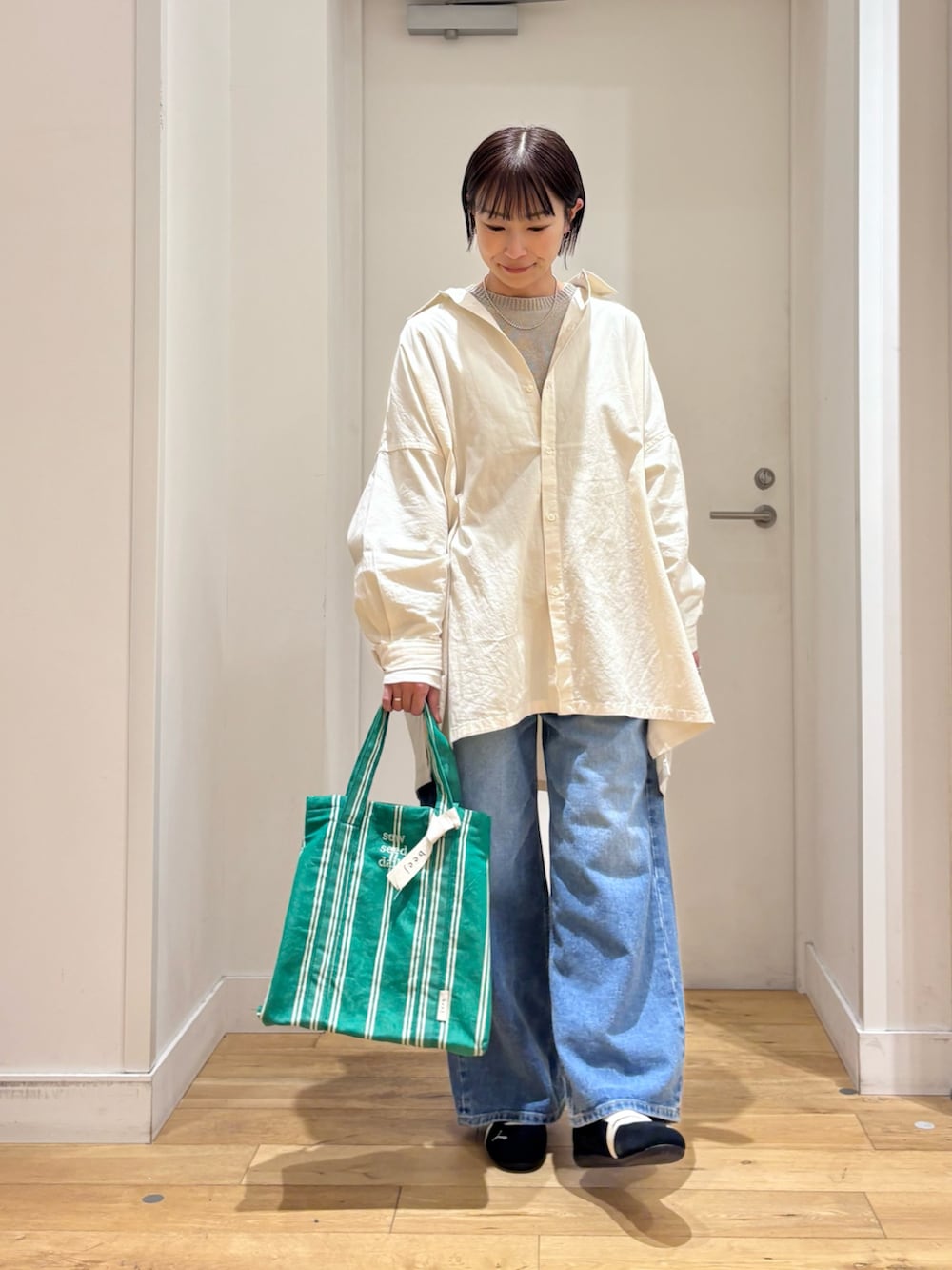 グレー系のニット/セーター、ブルー系のデニムパンツ、ブラック系のスニーカーを着用したレディースの春コーディネートの3枚目の写真