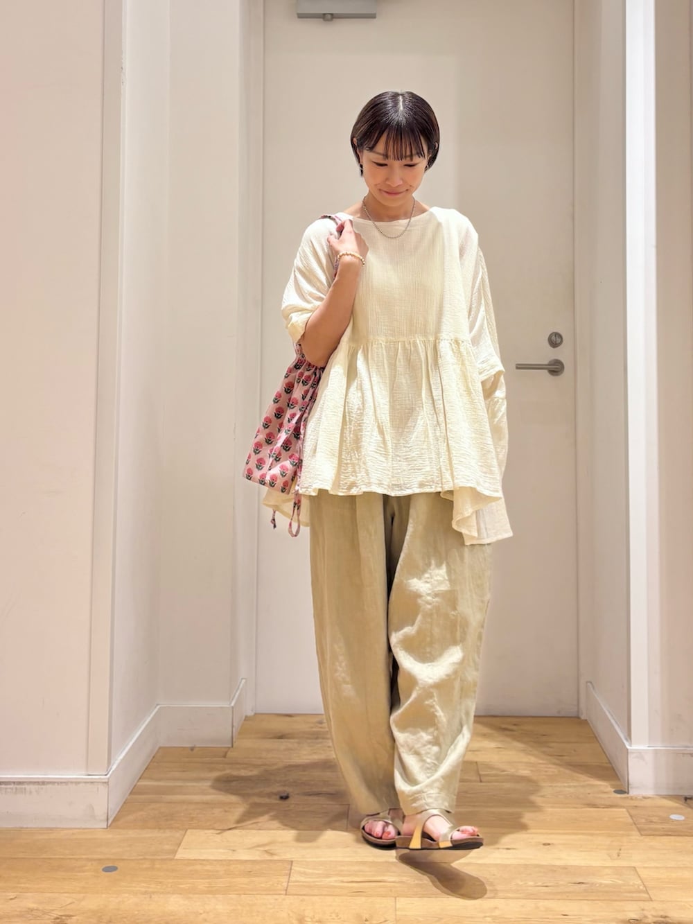 ホワイト系のシャツ/ブラウス、ベージュ系のその他パンツ、ゴールド系のサンダルを着用したレディースの夏コーディネートの2枚目の写真