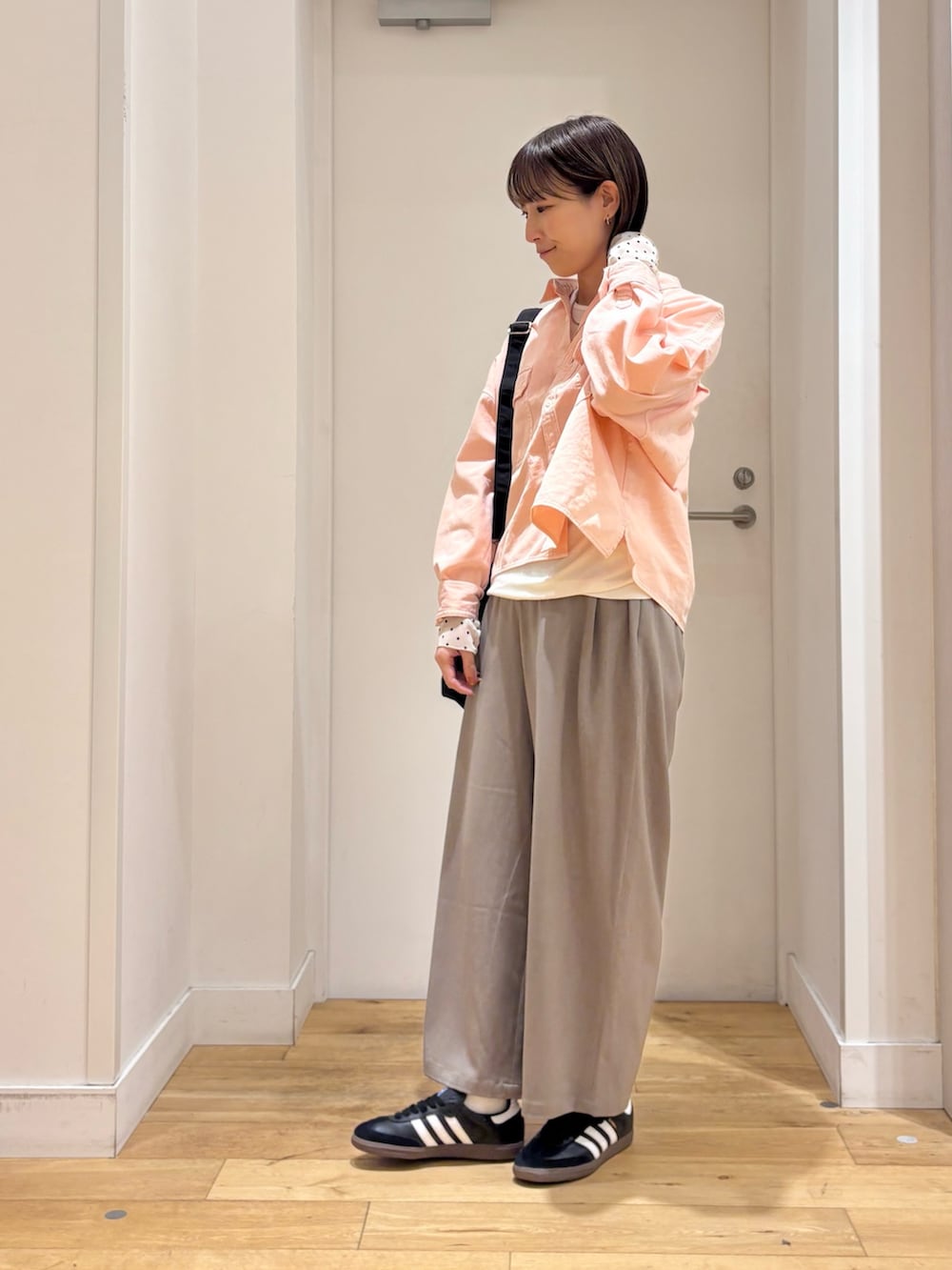 ピンク系のシャツ/ブラウス、ホワイト系のTシャツ/カットソー、ブラック系のスニーカーを着用したレディースの冬コーディネートの4枚目の写真