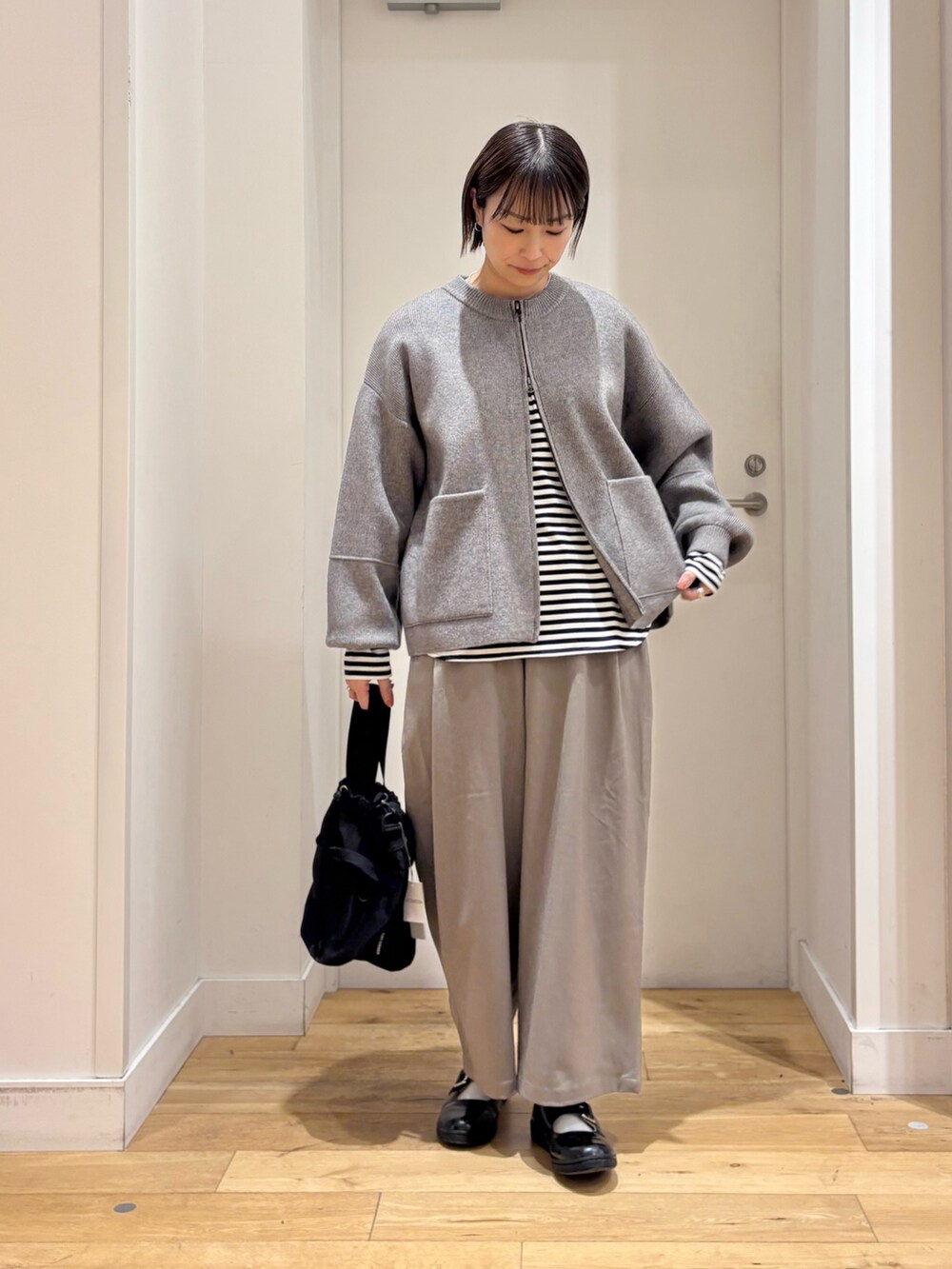 グリーン系のニット/セーター、ホワイト系のTシャツ/カットソー、グレー系のその他パンツを着用したレディースの冬コーディネートの3枚目の写真