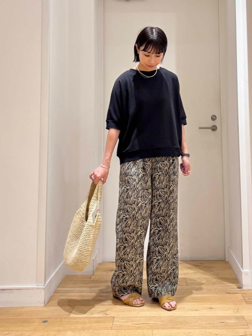 ベージュ系のトートバッグ、イエロー系のサンダル、グレー系のその他パンツを着用したレディースの夏コーディネートの3枚目の写真