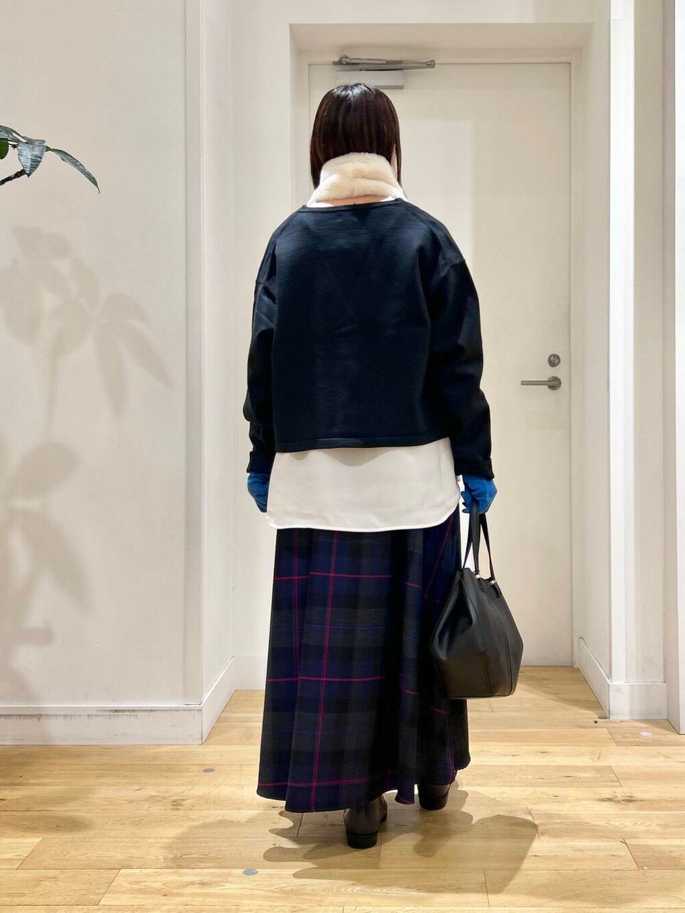 ブラック系のショルダーバッグ、グレー系のブーツ、ブラック系のカーディガン/ボレロを着用したレディースの秋コーディネートの6枚目の写真