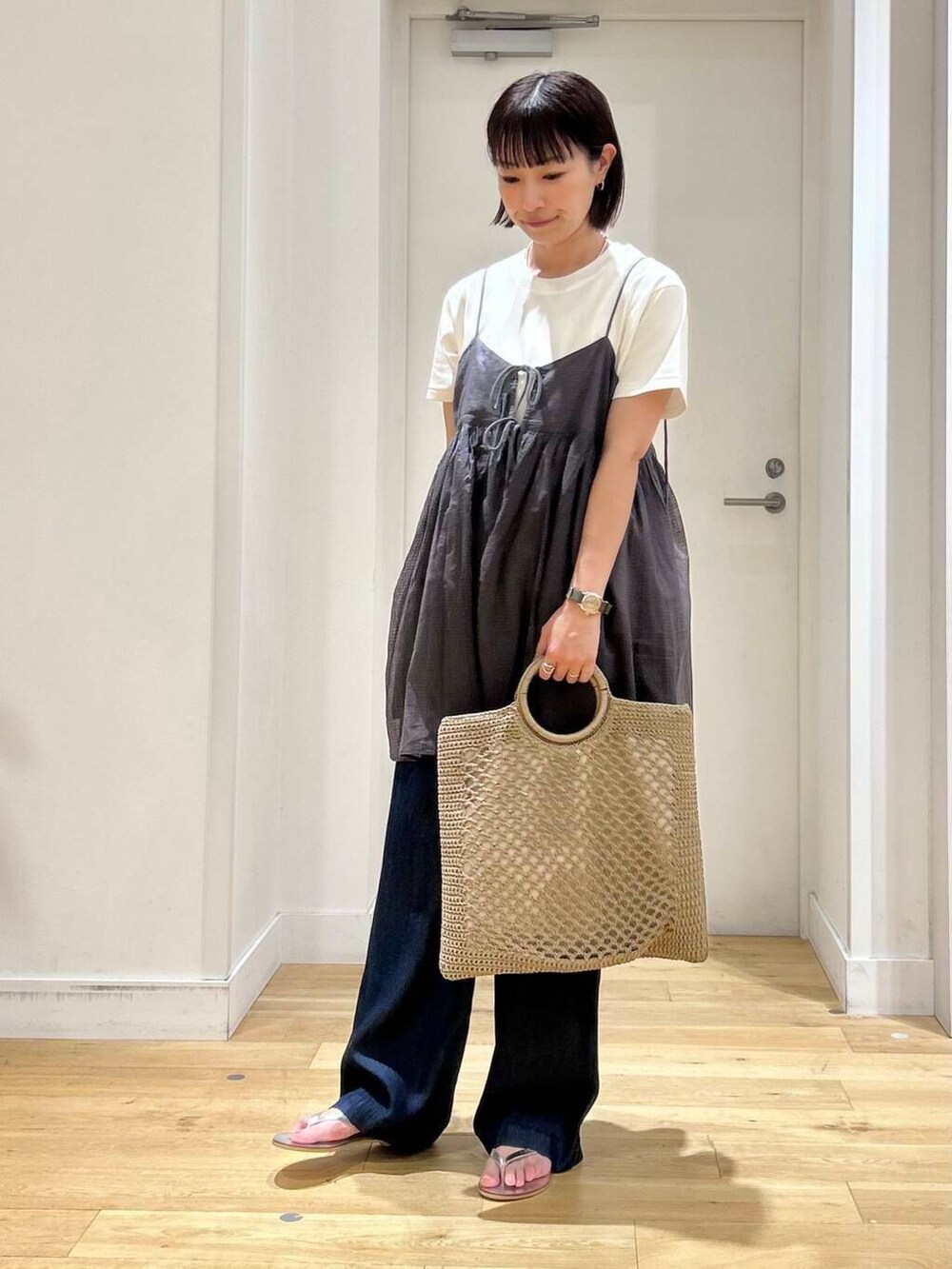 ブルー系のデニムパンツ、ホワイト系のTシャツ/カットソー、シルバー系のサンダルを着用したレディースの夏コーディネートの4枚目の写真